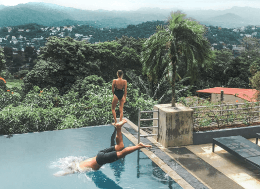 A couple swimming in the infinity pool of Theva Residency