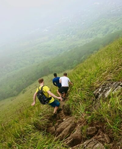 Group of tourists hiking the misty Hanthana mountain range